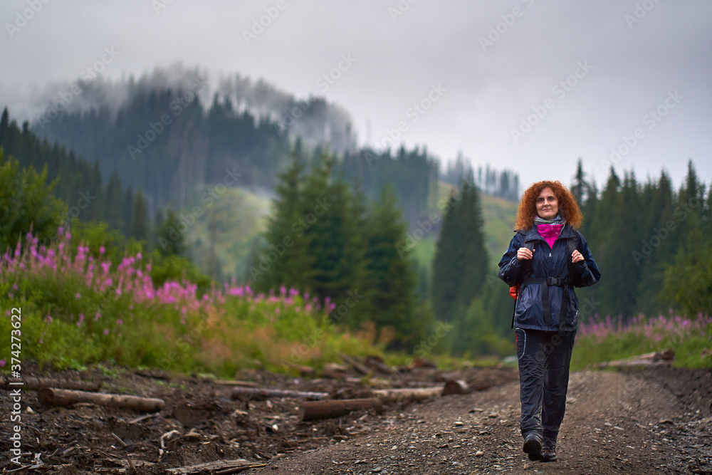 Backpacker with raincoat hiking