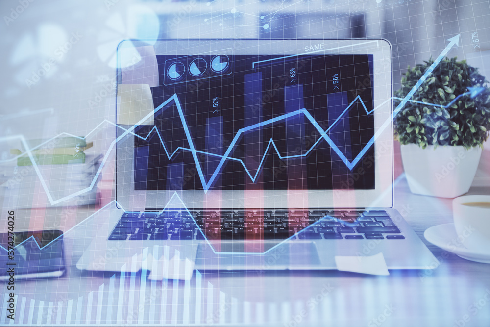 Financial graph colorful drawing and table with computer on background. Double exposure. Concept of international markets. Financial graph colorful drawing and table with computer on background. Double exposure. Concept of international markets.