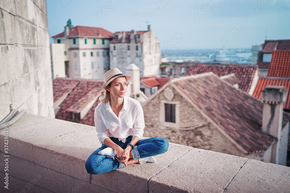 Traveling by Croatia. Young traveling woman enjoying old town Split view, red tiled roofs and ancient architecture.