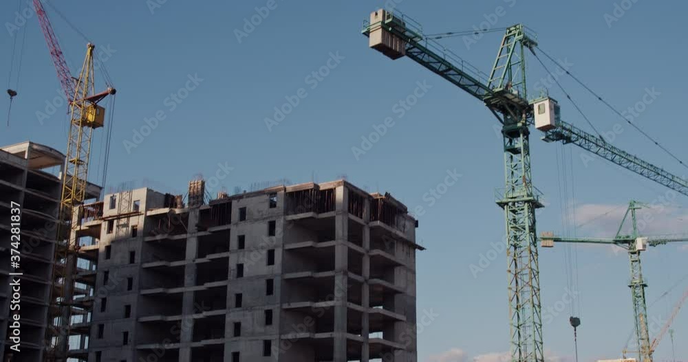 Crane and building under construction against blue sky Crane and building under construction against blue sky