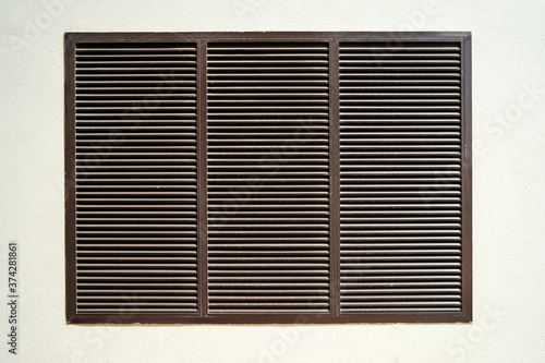 Brown shutters, louvers. Window on the wall. Textured background.