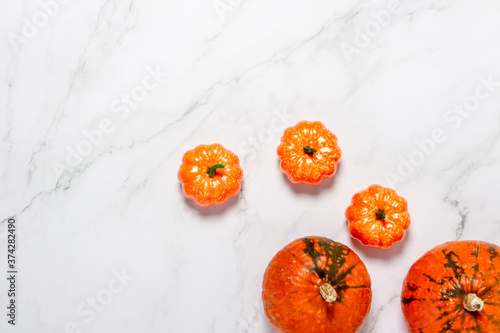 Pumpkins on marble background. Concept halloween, autumn, harvest. Flat lay, top view