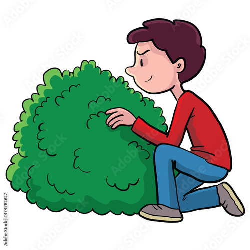 boy hiding behind a bush and watching