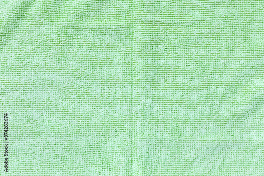 Fototapeta premium Green microfiber cloth for cleaning. Cleaning micro fabric towels for dusting and polishing. Domestic household cleaning service concept. Close up, copy space