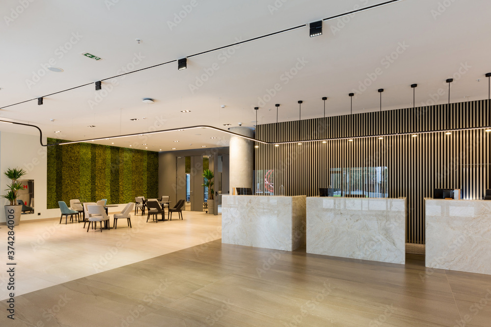 Interior of a hotel lobby with reception desks with transparent covid