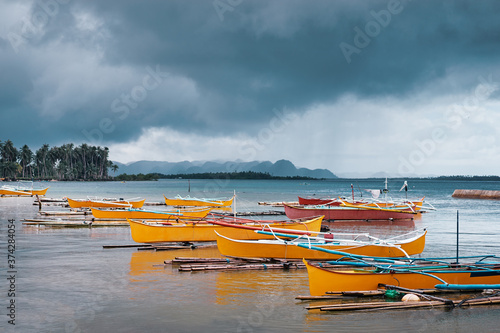 Tropical fishing boats harbour at rainy day. Siargao, Philippines.