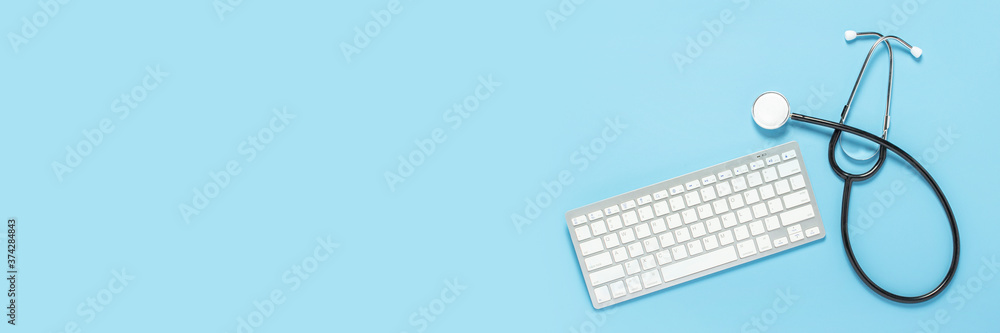 Keyboard and medical stethoscope on a blue background. Concept medicine, hospital, safety, epidemic, doctor's call, online, consultation. Banner. Flat lay, top view Keyboard and medical stethoscope on a blue background. Concept medicine, hospital, safety, epidemic, doctor's call, online, consultation. Banner. Flat lay, top view