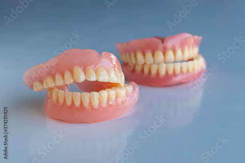 The dentures of the two elderly people were placed on a shiny white table.