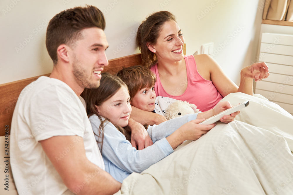 Eltern und Kinder beim fernsehen im Bett Stock Photo | Adobe Stock