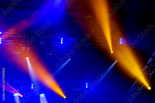 Stage lights. Background in show. Light spotlight in the dark. The interior of the theater scene is illuminated to the projector. Stage lights and stage smoke during the concert