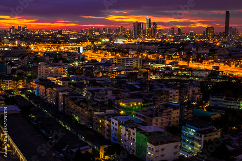 The high angle background of the city view with the secret light of the evening, blurring of night lights, showing the distribution of condominiums, dense homes in the capital community © bangprik