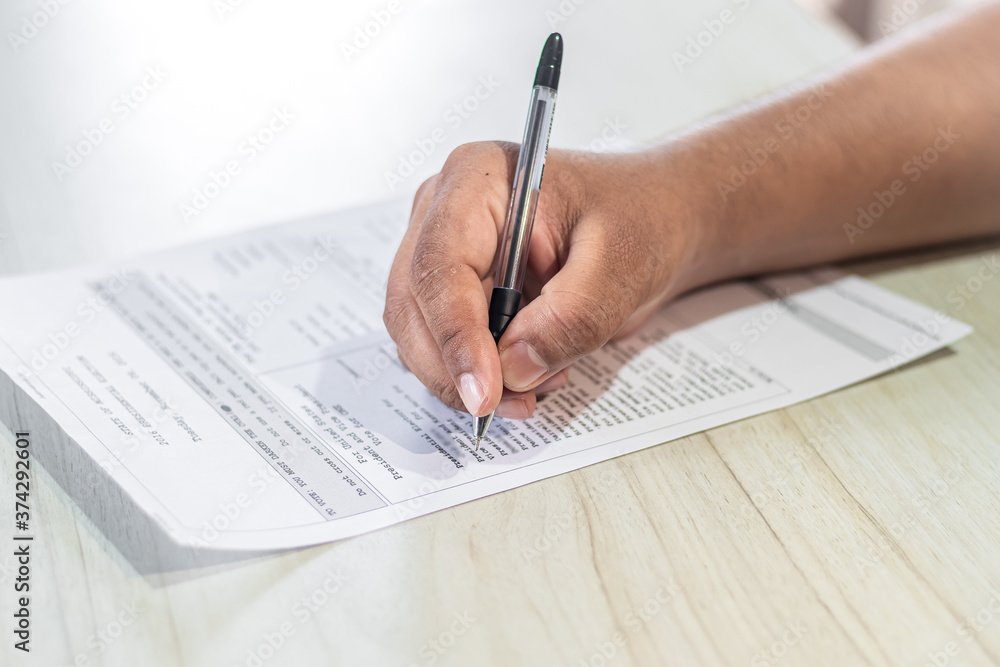 Voting Concept. Hand of an Asian man casts vote on the ballot paper in US Election. Voting Concept. Hand of an Asian man casts vote on the ballot paper in US Election.