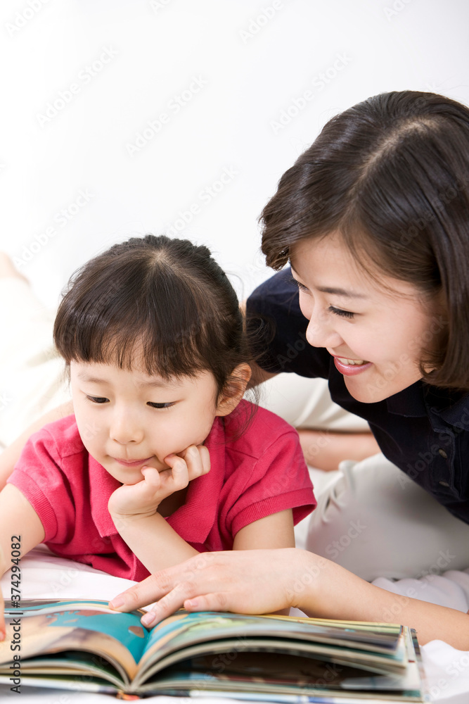 girl reading a book with mother girl reading a book with mother