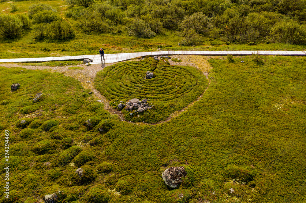 a panoramic view of an uninhabited island with an old church and ancient stone labyrinths filmed from a drone