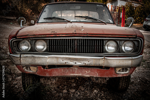 Lefkada, Greece. Front view of abandoned orange rusty old car. © Alessandro