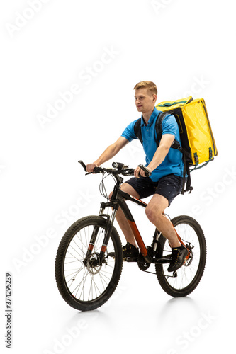 Riding. Deliveryman with bicycle isolated on white studio background. Contacless service during quarantine. Man delivers food during isolation. Safety. Professional occupation. Copyspace for ad.