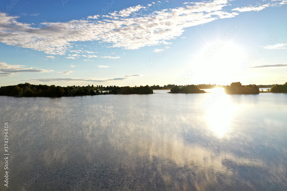 panoramic view of the lake with many islands on one of them there is an ancient temple made of wood at sunset filmed from a drone