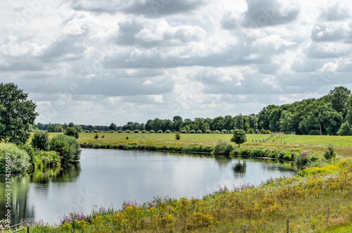 Bend in the river Vecht near Zwolle, The Netherlands in a green landscape under a dramatic sky on a summer day