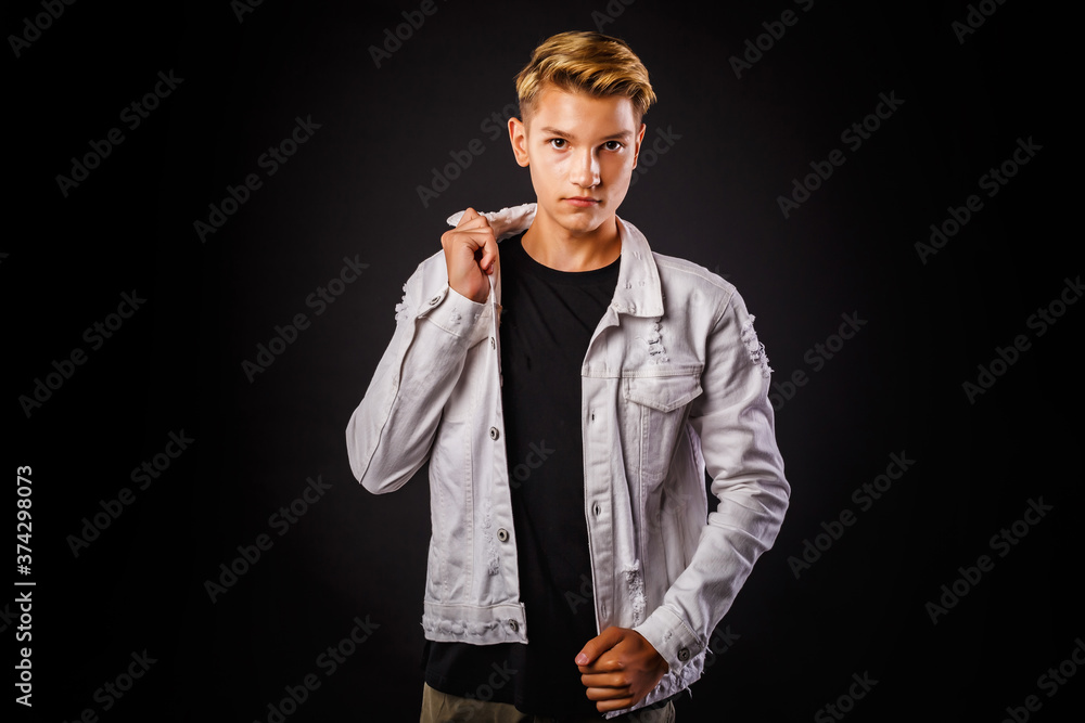 Fashion glamorous portrait of a handsome boy in white jacket on dark background. Fashion glamorous portrait of a handsome boy in white jacket on dark background.