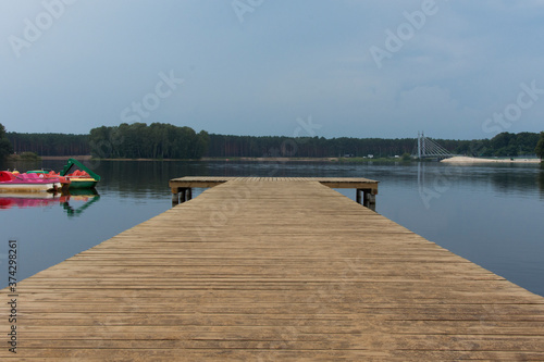 Wooden pier on a lake. Cloudy day in a holiday resort. © Justyna