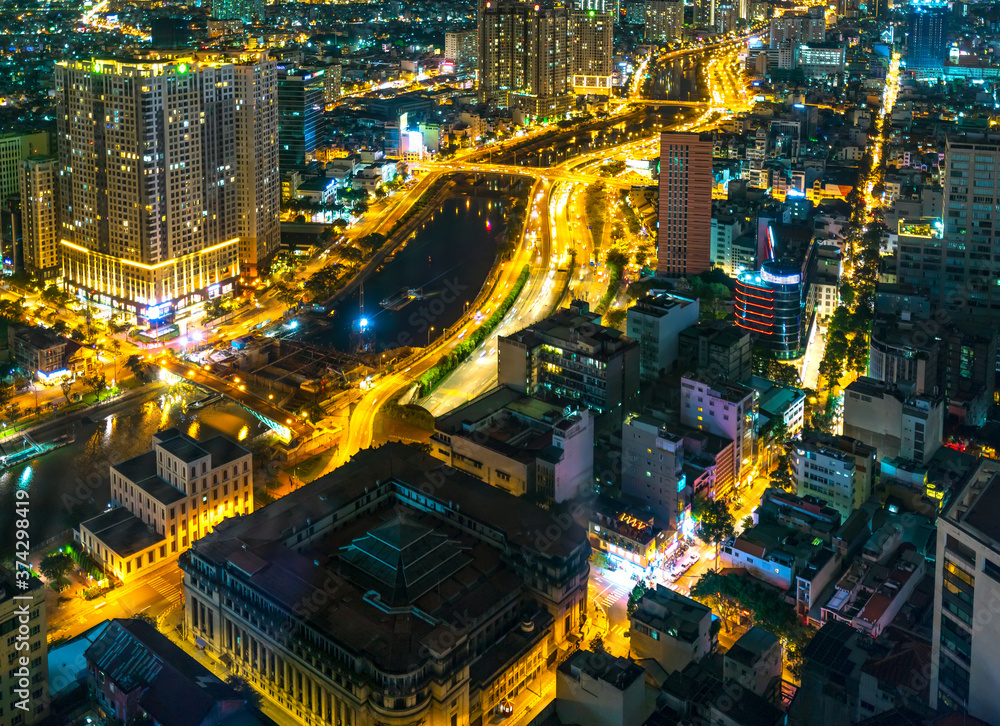 Fototapeta premium Night cityscape from above with lightstreet riverside create shimmering nocturnal beauty city developing dynamically in Ho Chi Minh City, Vietnam