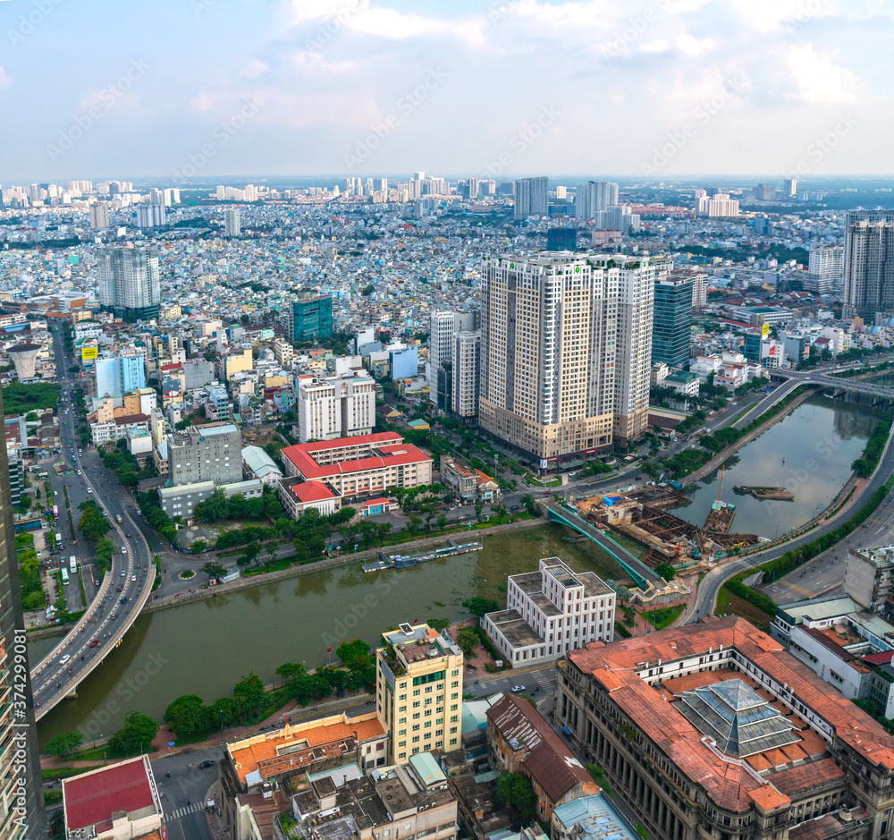 Obraz premium High view Saigon central skyline when afternoon down urban areas with tall buildings along river showing development country in Ho Chi Minh City, Vietnam