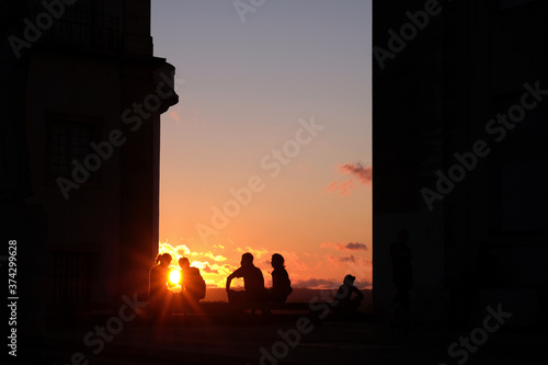Silhouette of people sitting while watching the sunset in Coimbra, Portugal 