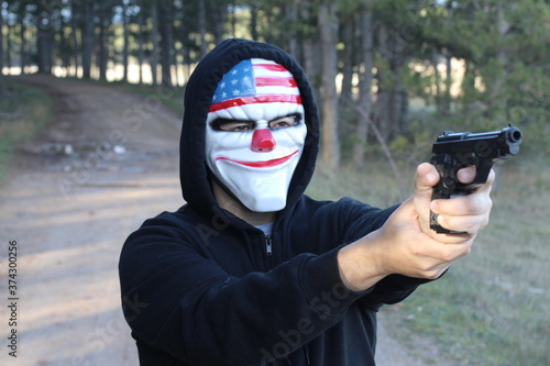 Принти на полотні Spooky clown holding gun in the forest