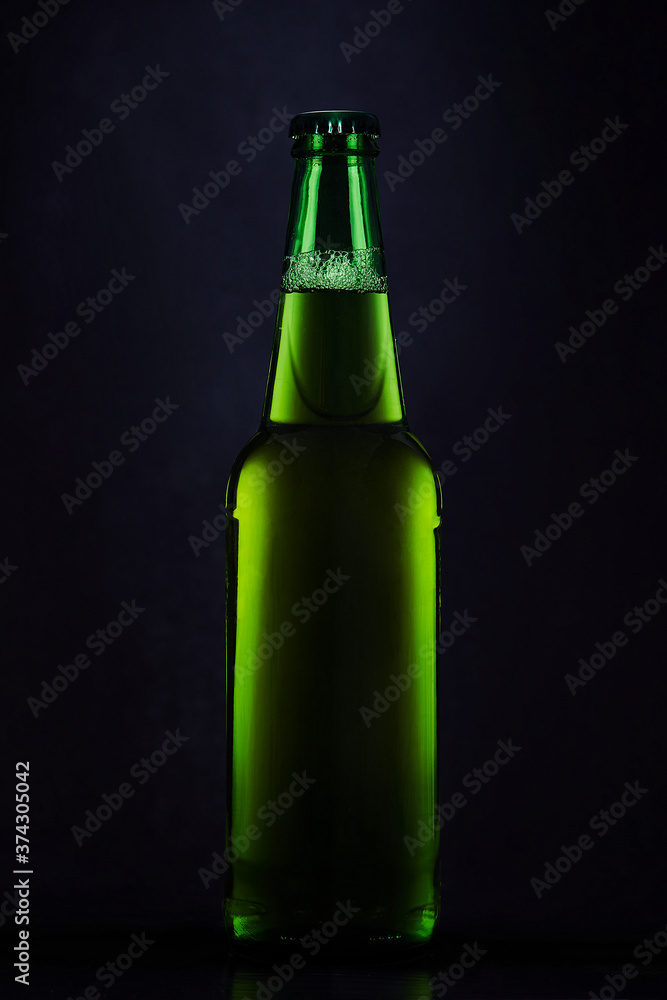 Green bottle of beer on a dark background