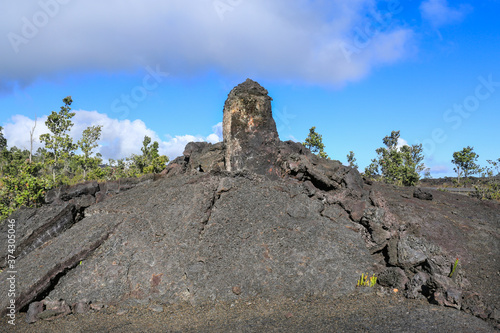 Lava pillars against the blue sky with white clouds in Hawaii.
