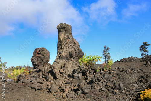 Lava pillars against the blue sky with white clouds in Hawaii.