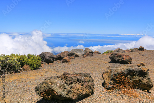 Large stones on the edge of the volcano Haleakala, Maui, against a background of blue sky and white clouds
