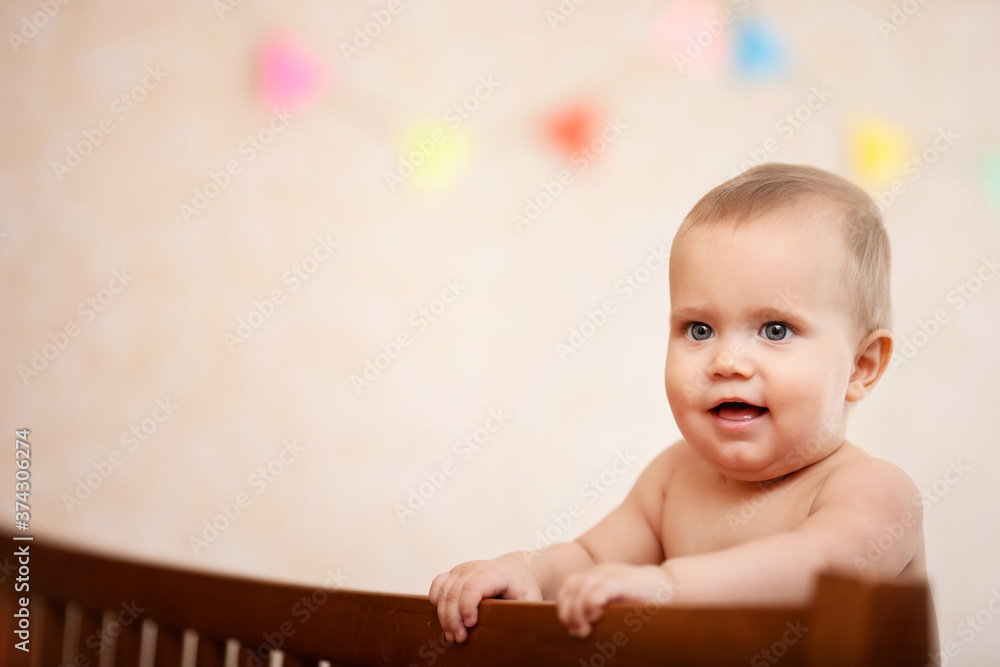 Naked happy laughing baby standing in crib. Naked happy laughing baby standing in crib.