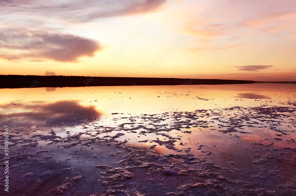 Salt lake at sunset with dramatic sky reflection in the water. Calm evening landscape.