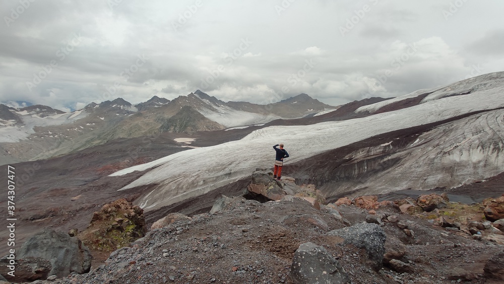 hiker in the mountains of caucasus. view on ice peaks from elbrus