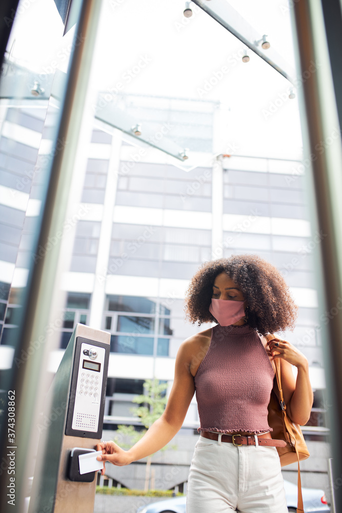 Young adult woman entering office wearing face mask