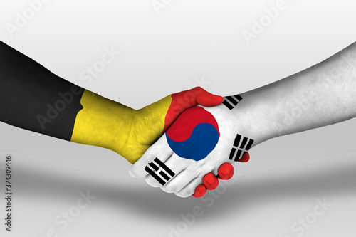 Handshake between south korea and belgium flags painted on hands, illustration with clipping path.