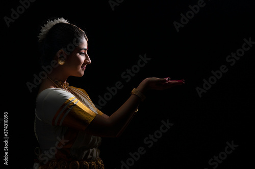 Mohiniattam artist looking at her hands with a smile
 photo