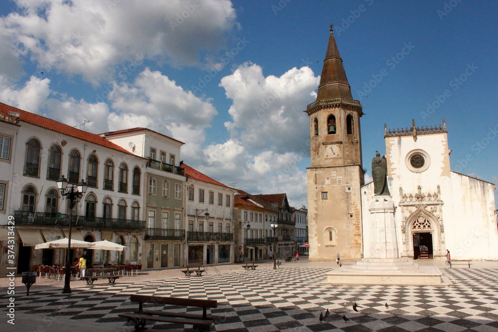 Scene of the main square (praca da republica), and Saint John the Baptist church, with locals and visitors, in Tomar, Portugal