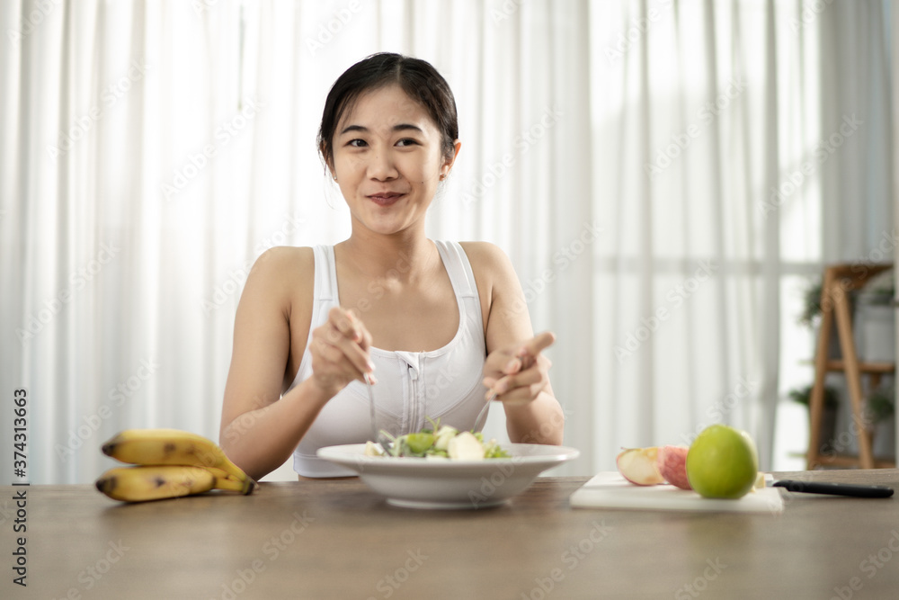 A healthy woman is mixing a spoon and fork in her home. Healthy weight loss ideas. A healthy woman is mixing a spoon and fork in her home. Healthy weight loss ideas.