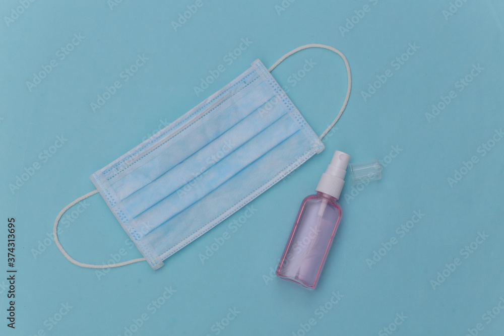 Hygiene. Virus protection. Antiseptic and facial mask on blue background. Top view Hygiene. Virus protection. Antiseptic and facial mask on blue background. Top view