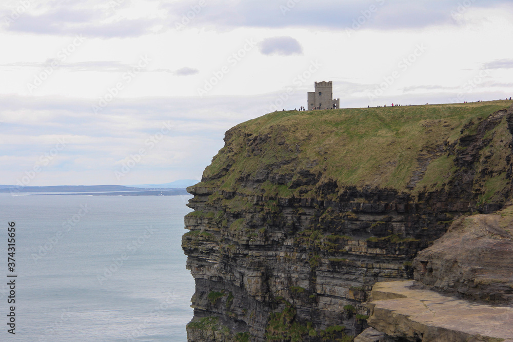 Stone castle above the Cliffs of Moher in Ireland, surrounded by vegetation
