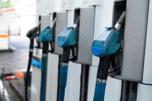 A row with four blue gas pump nozzles