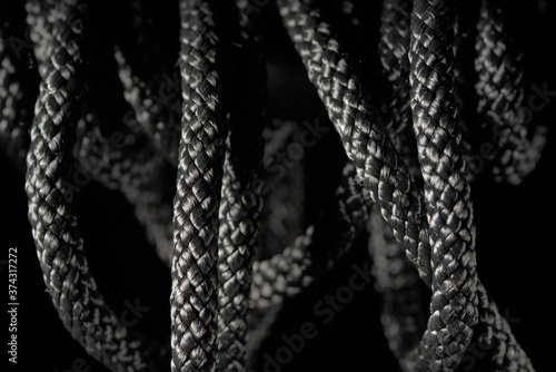 Black twisted rope on a black background © Juri