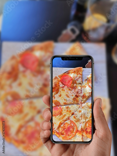 Chico haciendo foto con su móvil a comida en un restaurante