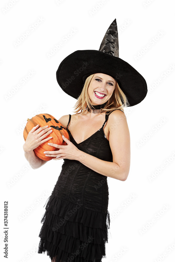 jeune et jolie femme blonde souriante déguisée en sorcière d'Halloween sexy  avec un chapeau pointu sur fond isolé blanc de studio Stock Photo | Adobe  Stock