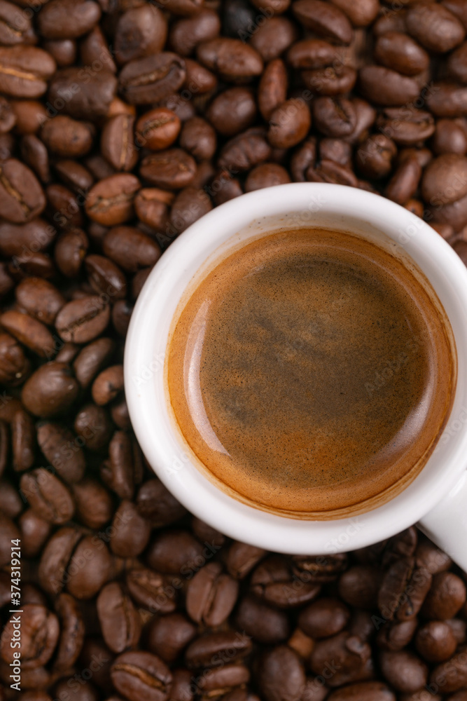 Mugful of coffee in white cup and saucer with coffee grains background Mugful of coffee in white cup and saucer with coffee grains background