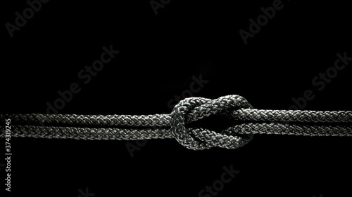 Reef knot black rope on a black background. photo