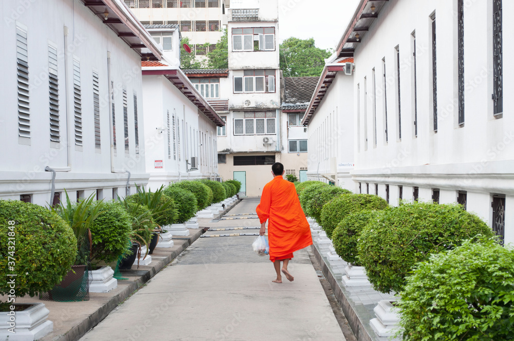 Buddhist monks who are doing daily routines every morning by going out to get food from the people waiting to eat. Buddhist monks who are doing daily routines every morning by going out to get food from the people waiting to eat.