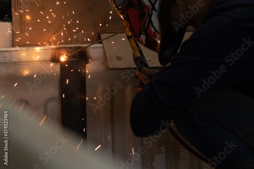 Worker,welding in a car factory with sparks, manufacturing, industry